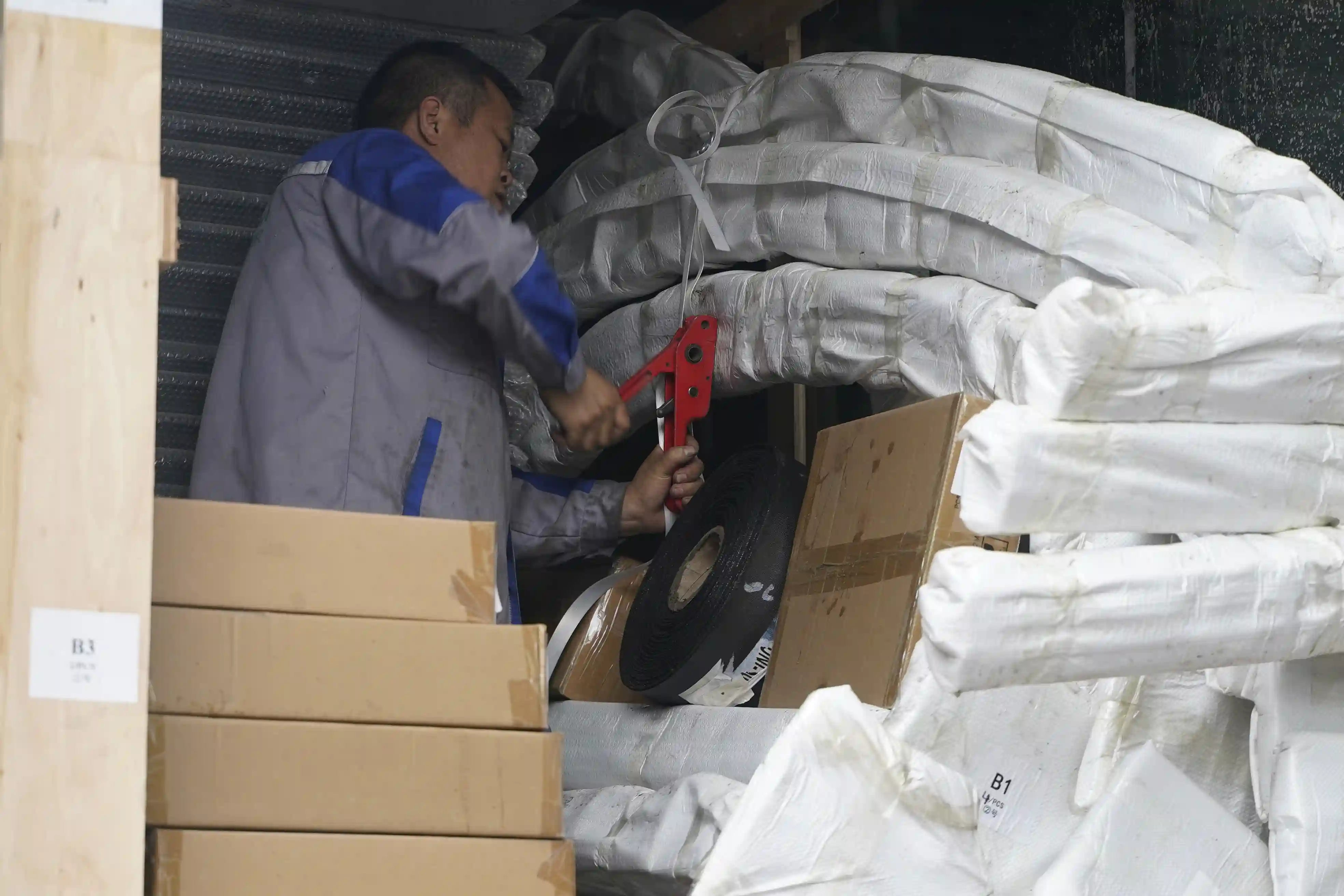 Wrapped padel court components being secured inside a shipping container